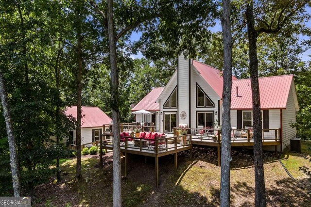 back of house with central AC unit and a wooden deck