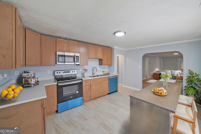 kitchen featuring a kitchen breakfast bar, crown molding, sink, and appliances with stainless steel finishes