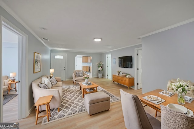 living room with crown molding and light wood-type flooring