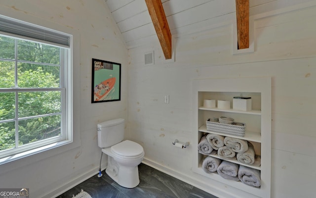 bathroom with a wealth of natural light, toilet, and vaulted ceiling with beams