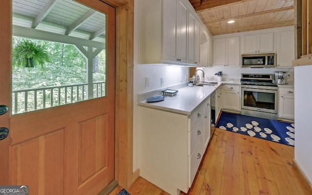 kitchen with wooden ceiling, stainless steel appliances, plenty of natural light, and white cabinetry