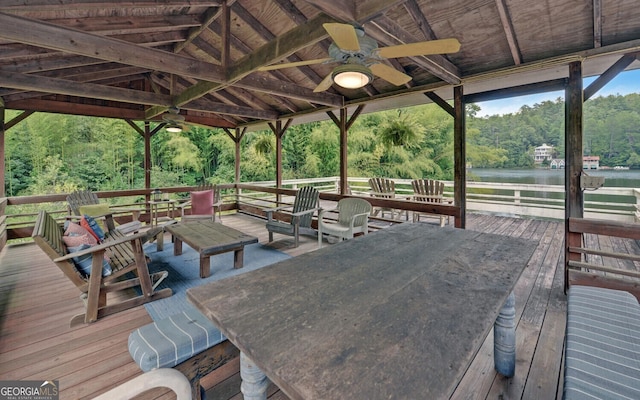 deck featuring ceiling fan and a water view