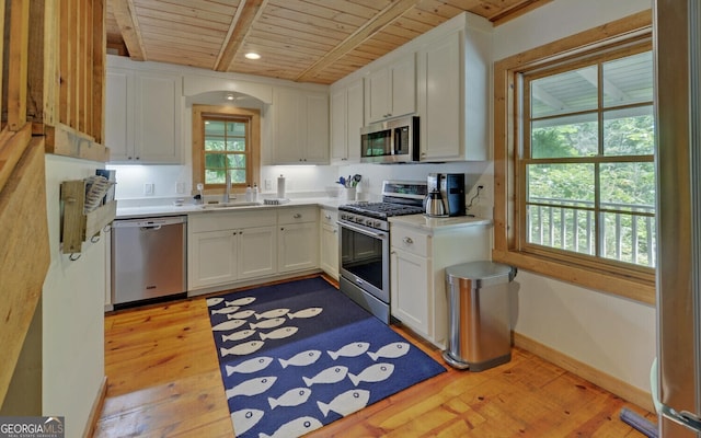 kitchen with white cabinetry, wooden ceiling, and stainless steel appliances