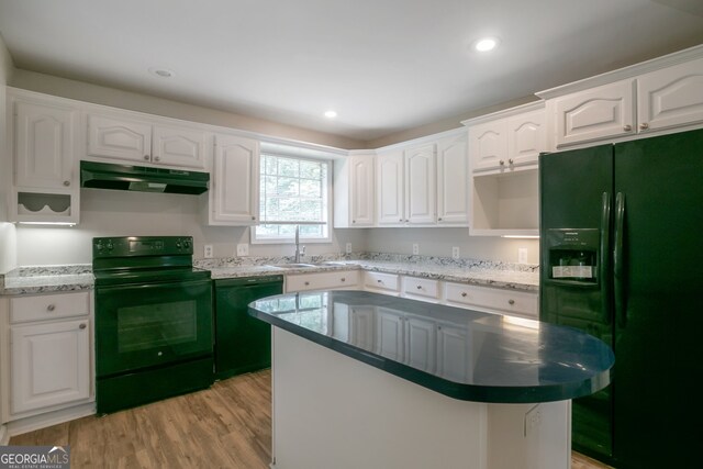 kitchen with light wood-type flooring, white cabinets, sink, black appliances, and a center island