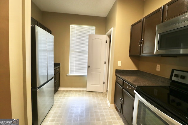 kitchen featuring dark brown cabinetry, light tile patterned flooring, and stainless steel appliances