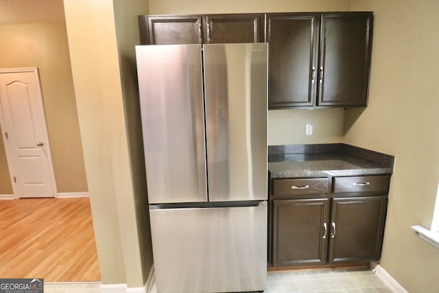 kitchen featuring light hardwood / wood-style flooring, stainless steel fridge, and dark brown cabinetry