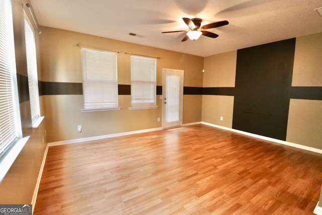 spare room with ceiling fan and light wood-type flooring