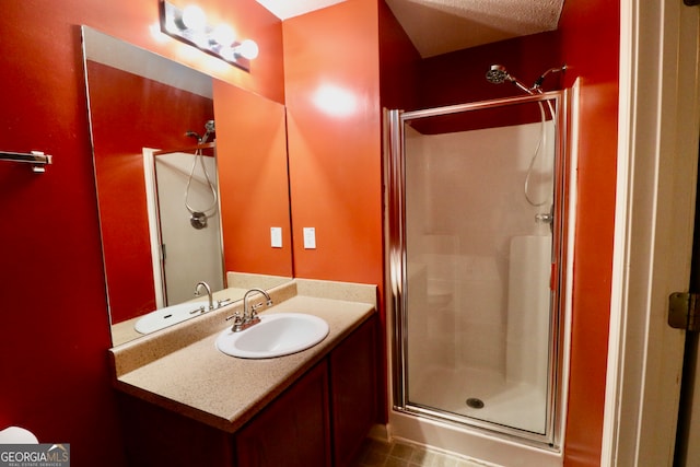 bathroom with tile patterned floors, a textured ceiling, vanity, and a shower with shower door