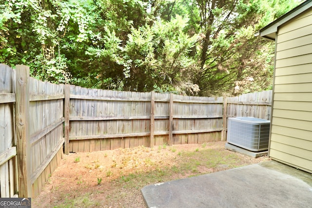 view of yard with central AC unit and a patio area