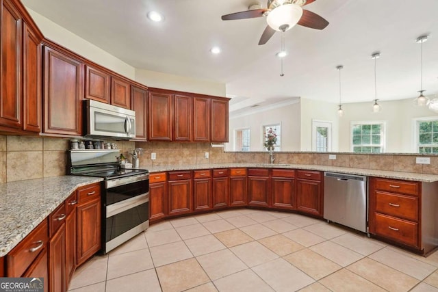 kitchen featuring light stone countertops, hanging light fixtures, stainless steel appliances, and tasteful backsplash