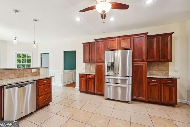 kitchen featuring decorative light fixtures, light tile patterned floors, light stone counters, decorative backsplash, and stainless steel appliances