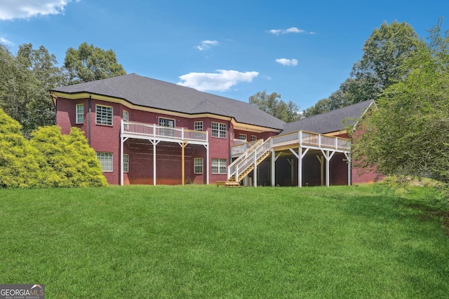 rear view of property featuring a lawn and a deck