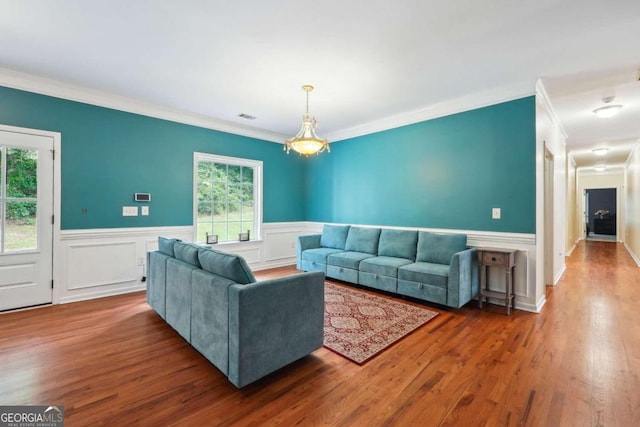 living room featuring plenty of natural light, wood-type flooring, and ornamental molding