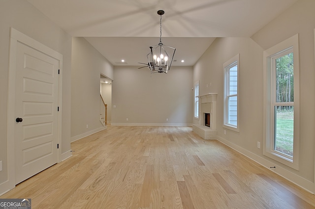 unfurnished room featuring a chandelier and light hardwood / wood-style floors