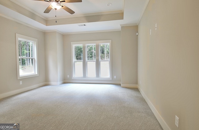 empty room featuring ceiling fan, light carpet, ornamental molding, and a healthy amount of sunlight