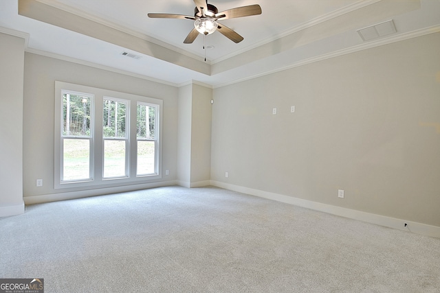 carpeted empty room featuring ornamental molding, ceiling fan, and a raised ceiling