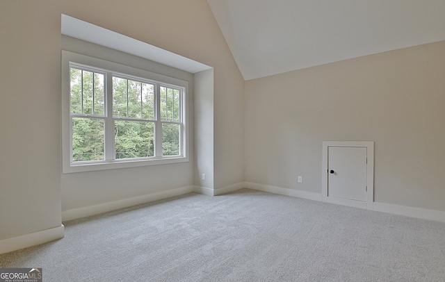 bonus room with light carpet and vaulted ceiling