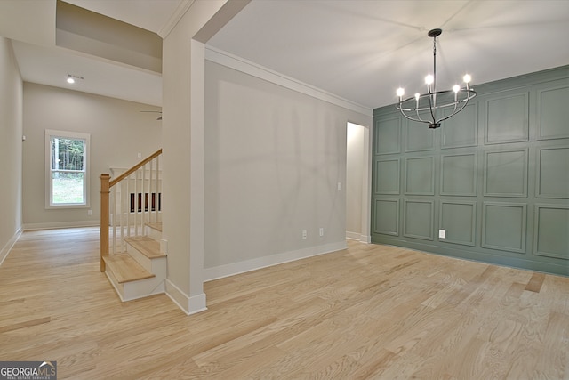 unfurnished dining area with light wood-type flooring, a chandelier, and ornamental molding