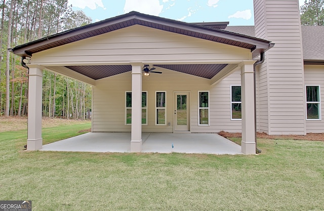 back of property with a lawn and a patio area