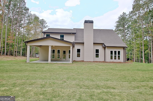 rear view of property with a yard and a patio area