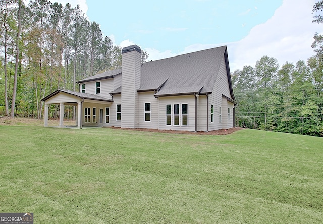 rear view of property featuring a yard and a patio area