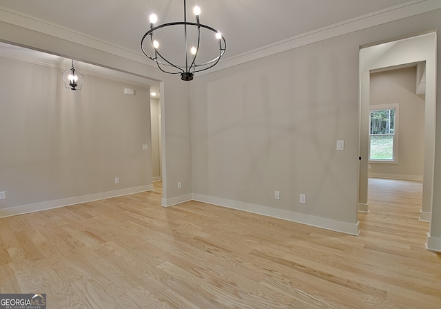 unfurnished dining area with an inviting chandelier, crown molding, and light hardwood / wood-style floors