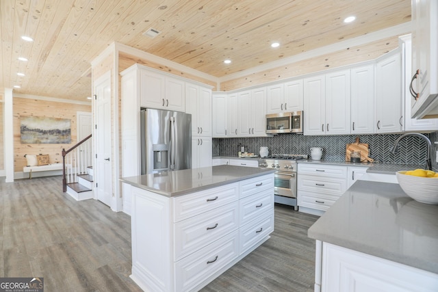 kitchen featuring stainless steel appliances, wood finished floors, a sink, wood ceiling, and white cabinets