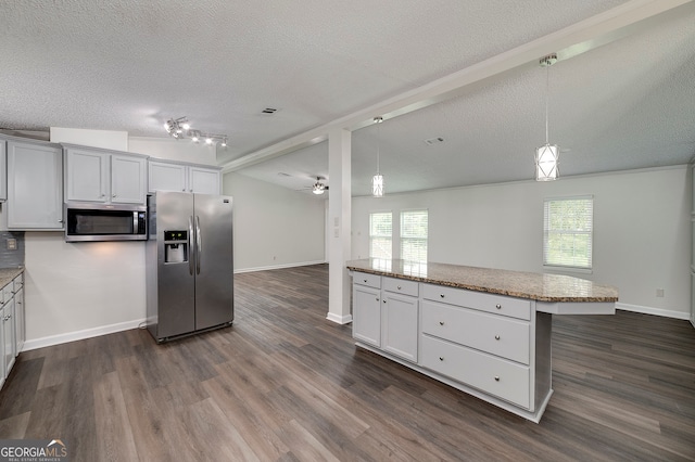 kitchen with track lighting, appliances with stainless steel finishes, plenty of natural light, and dark wood-type flooring