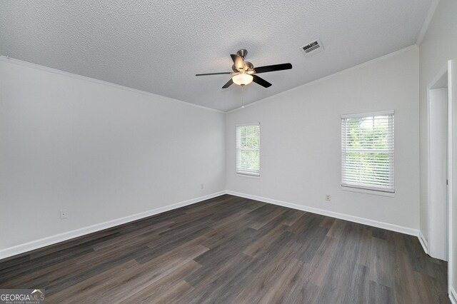 empty room featuring hardwood / wood-style flooring, crown molding, lofted ceiling, and a wealth of natural light