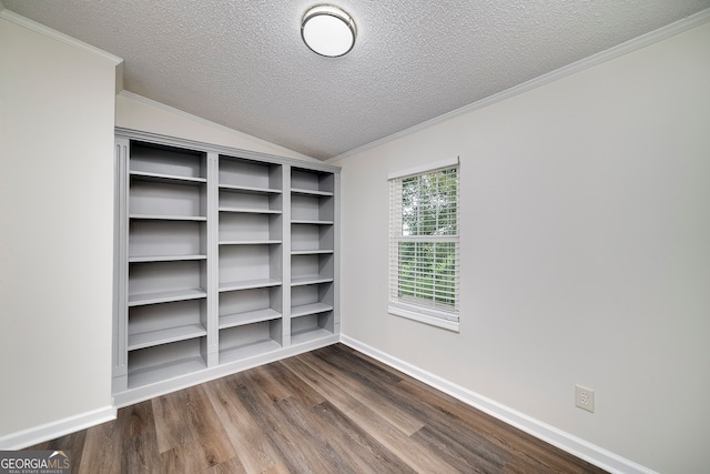 spare room featuring vaulted ceiling, a textured ceiling, crown molding, and hardwood / wood-style floors