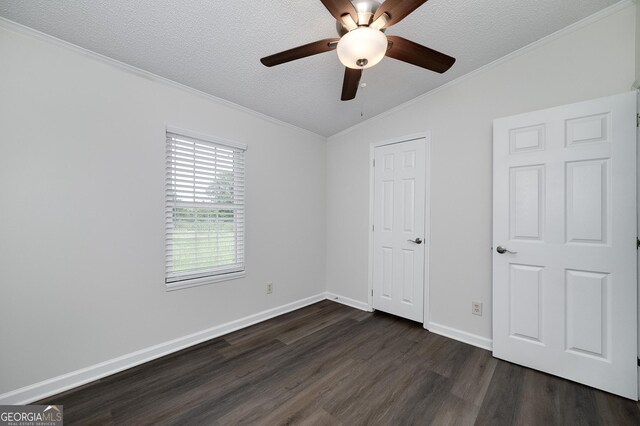 unfurnished bedroom with vaulted ceiling, dark hardwood / wood-style floors, crown molding, a textured ceiling, and ceiling fan