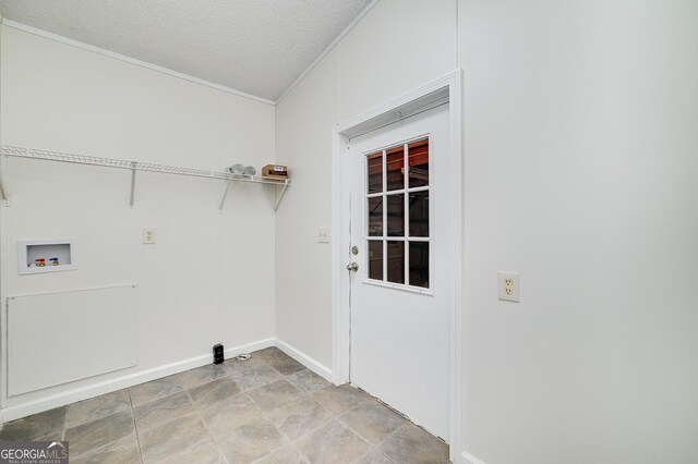 washroom featuring light tile patterned flooring, hookup for a washing machine, and a textured ceiling