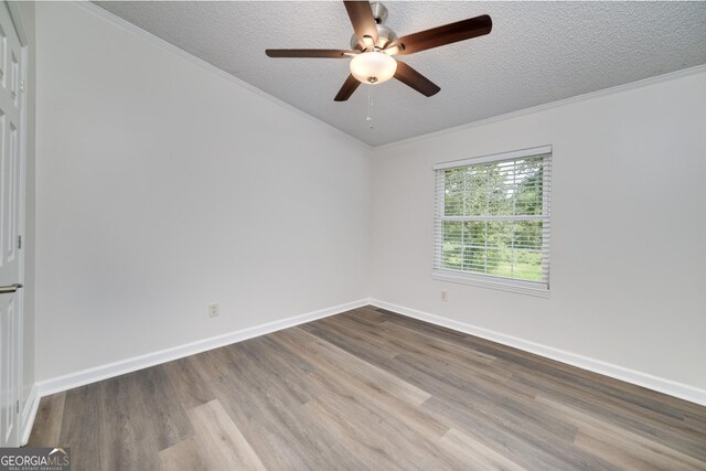 unfurnished room with hardwood / wood-style flooring, a textured ceiling, crown molding, and ceiling fan