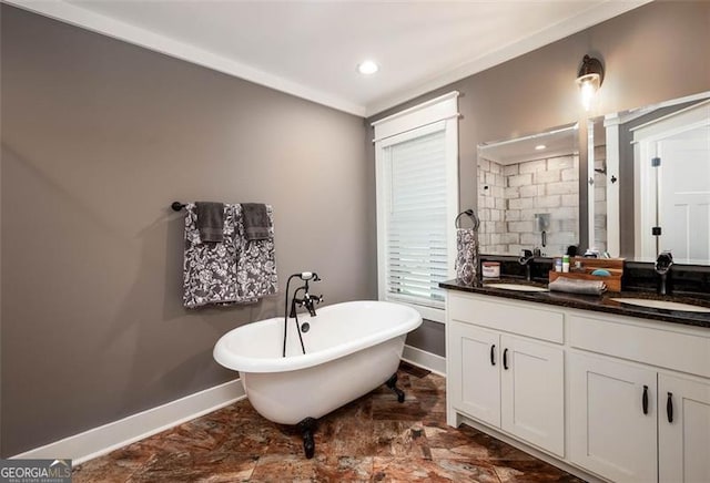 bathroom with tiled shower, a freestanding bath, baseboards, and a sink