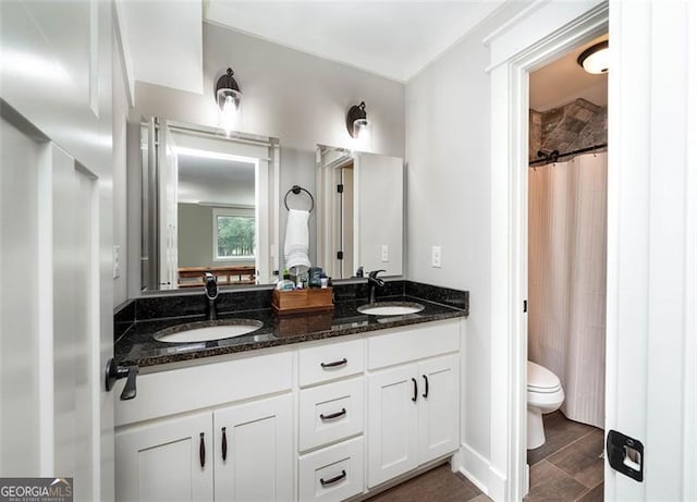 bathroom with a shower with shower curtain, double vanity, toilet, and a sink