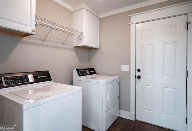 laundry room featuring washing machine and dryer, dark wood-type flooring, and cabinets