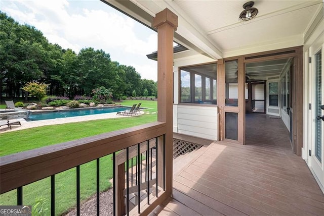 wooden terrace featuring a yard and an outdoor pool