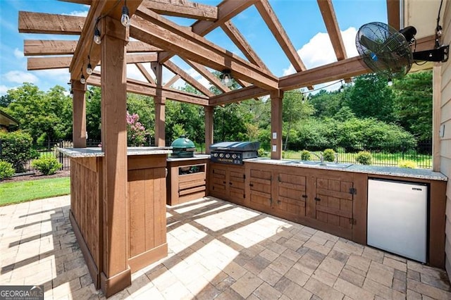 view of patio featuring grilling area, an outdoor kitchen, and fence