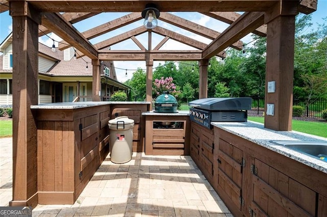 view of patio / terrace featuring area for grilling, exterior kitchen, and fence