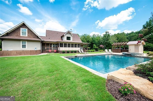 pool featuring a shed, a lawn, an outdoor structure, a sunroom, and a patio