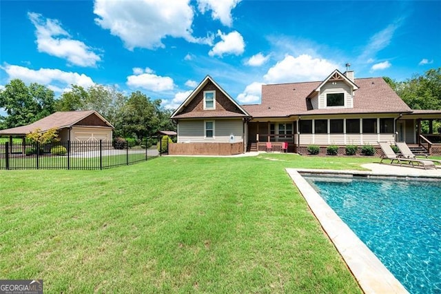 rear view of property featuring a sunroom, a lawn, a garage, a fenced backyard, and a patio