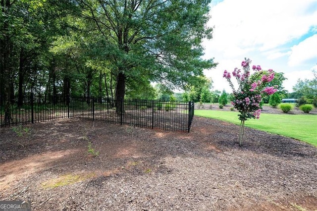 view of gate with a yard and fence