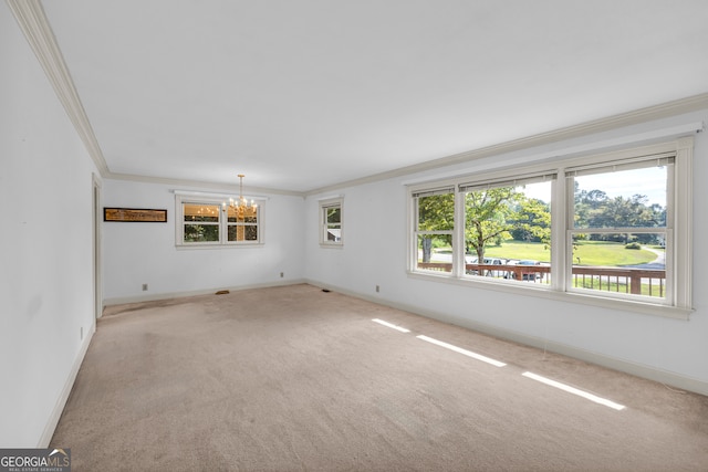 carpeted empty room with ornamental molding and a chandelier