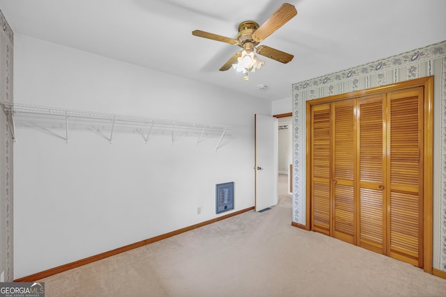 unfurnished bedroom with ceiling fan, a closet, and carpet floors