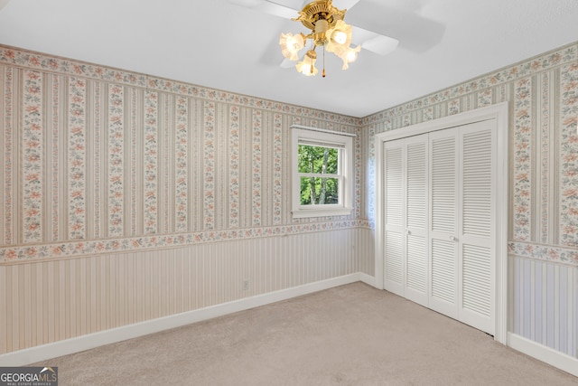 unfurnished bedroom with carpet flooring, ceiling fan, and a closet