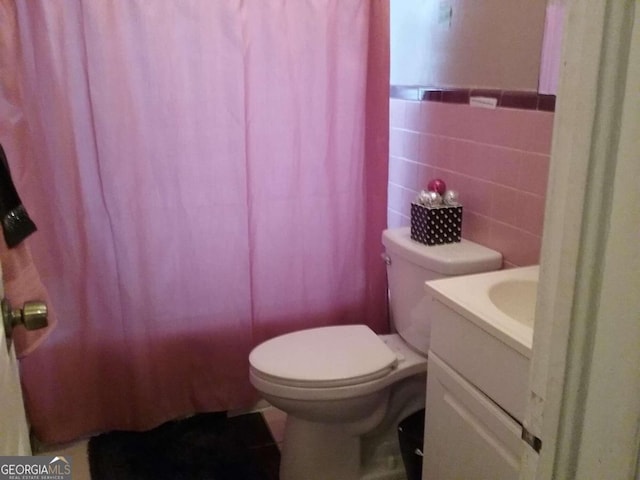 full bathroom with vanity, toilet, tile walls, and shower / bath combo