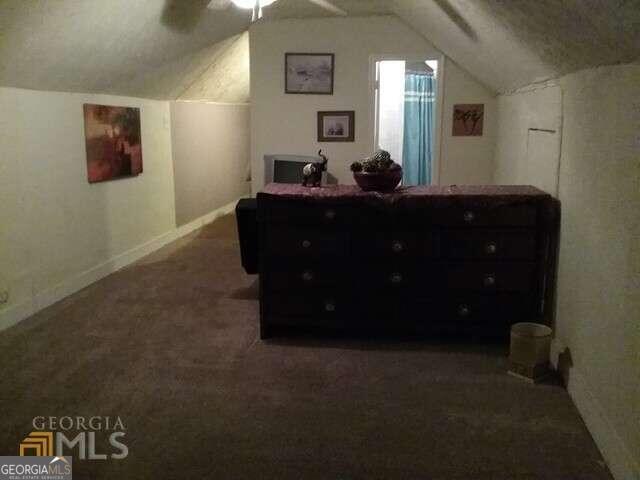 bedroom with vaulted ceiling, ceiling fan, and dark carpet