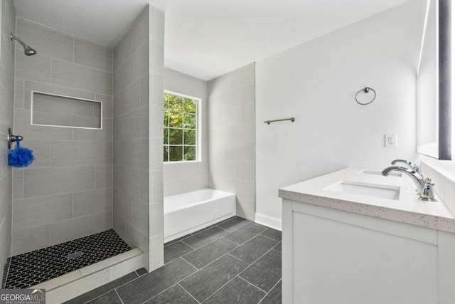 bathroom with tile patterned flooring, double vanity, and tiled shower