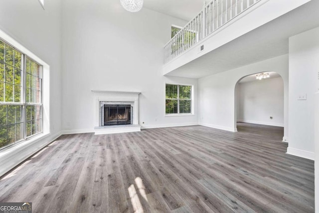 unfurnished living room featuring a premium fireplace, hardwood / wood-style flooring, and plenty of natural light