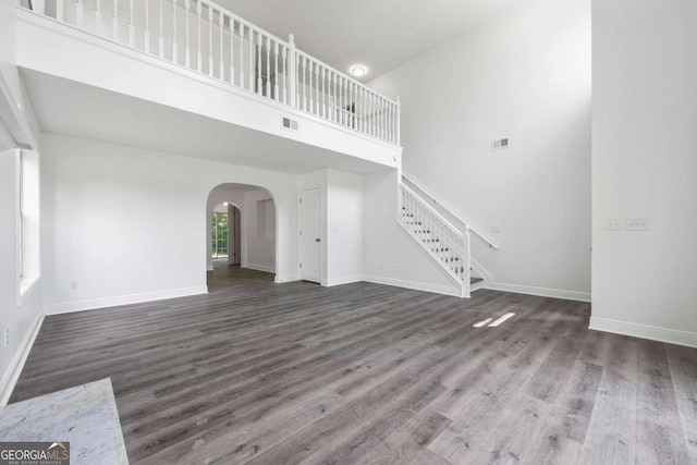 unfurnished living room with a high ceiling and hardwood / wood-style flooring